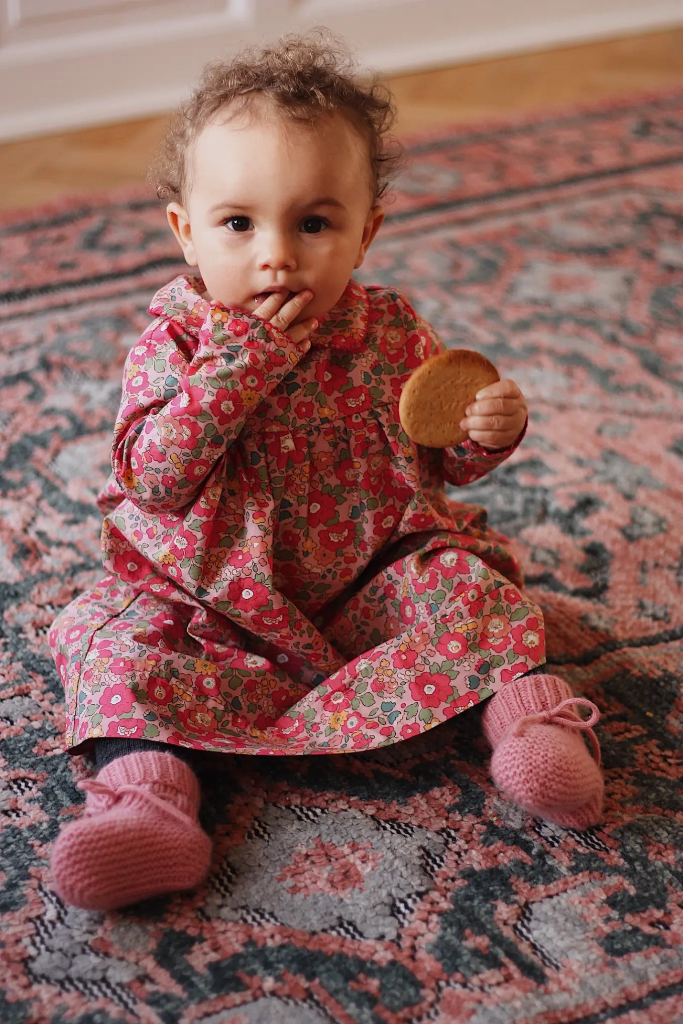 Baby girl wearing Lalaby Anna baby dress in Berry besty pink liberty organic cotton