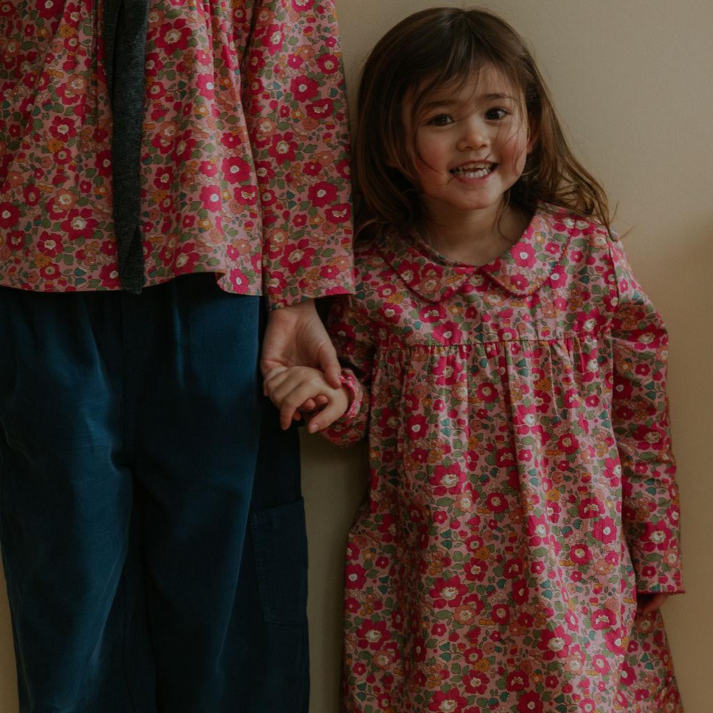 Girl wearing Lalaby Anna dress for kids in berry betsy pink liberty organic cotton