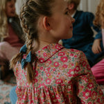 Girl wearing Lalaby Anna dress for kids in berry betsy pink liberty organic cotton
