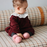 Baby girl wearing Lalaby Annabella baby dress in ruby red cotton baby corduroy