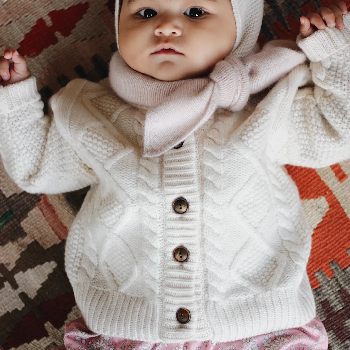Baby girl wearing Lalaby Atlas scarf for babies, kids and adults in powder pink cashmere