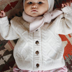Baby girl wearing Lalaby Atlas scarf for babies, kids and adults in powder pink cashmere