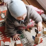 Baby girl wearing Lalaby Babar baby jacket in hazel brown merino wool