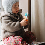 Baby girl wearing Lalaby Babar baby jacket in hazel brown merino wool