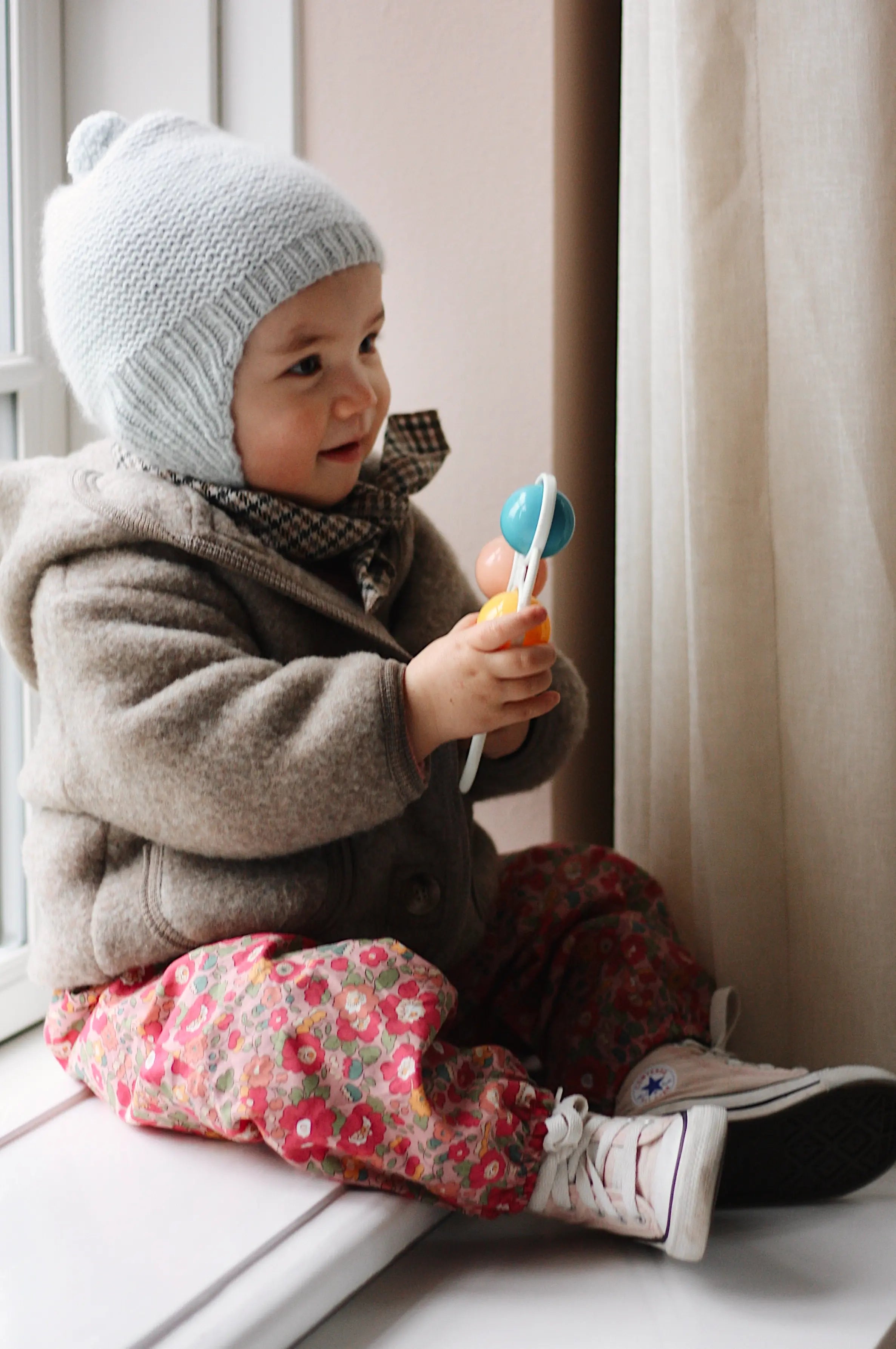 Baby girl wearing Lalaby Babar baby jacket in hazel brown merino wool