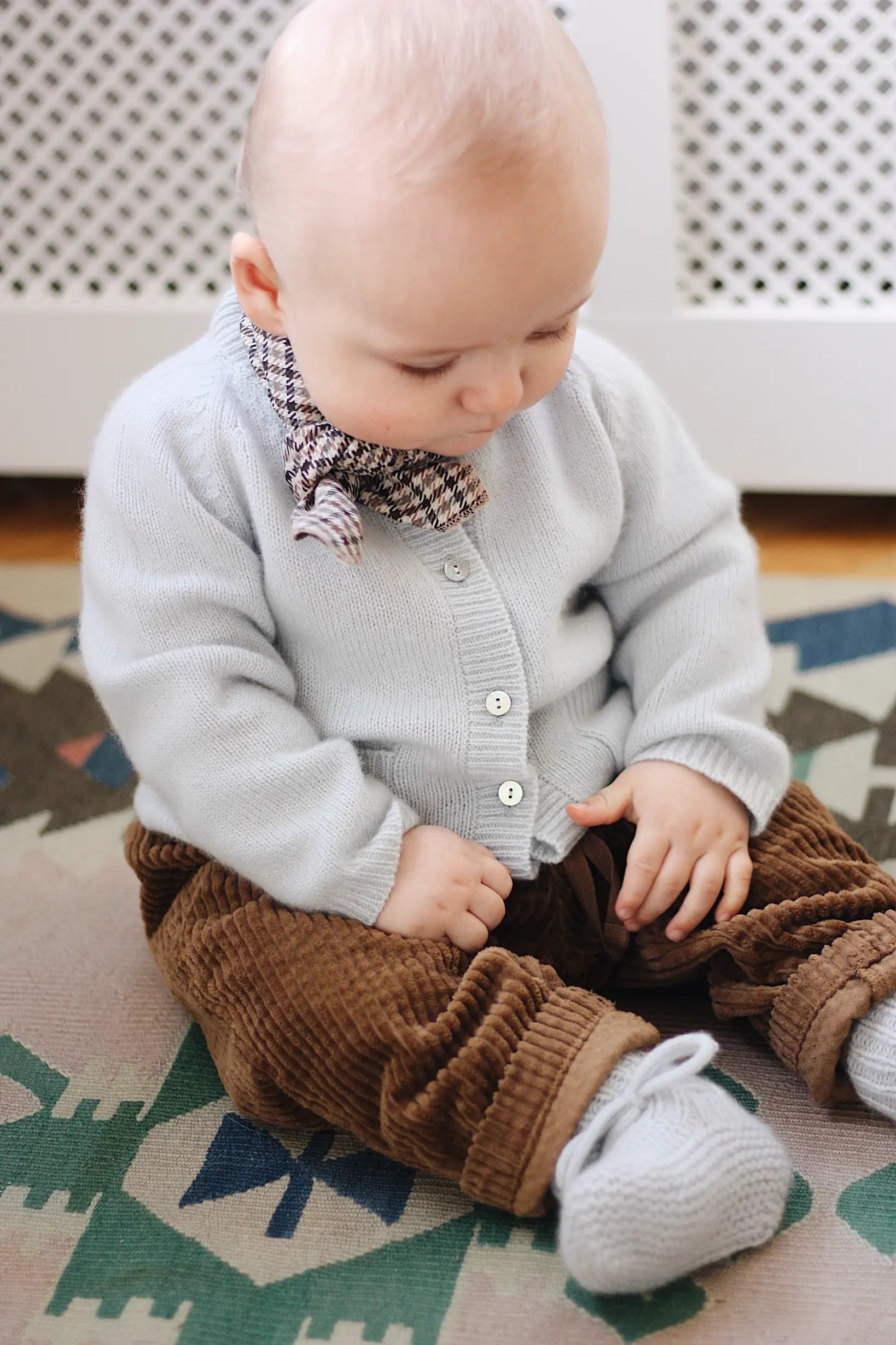 Baby boy wearing Lalaby Bobbie baby cardigan in bluey light blue cashmere
