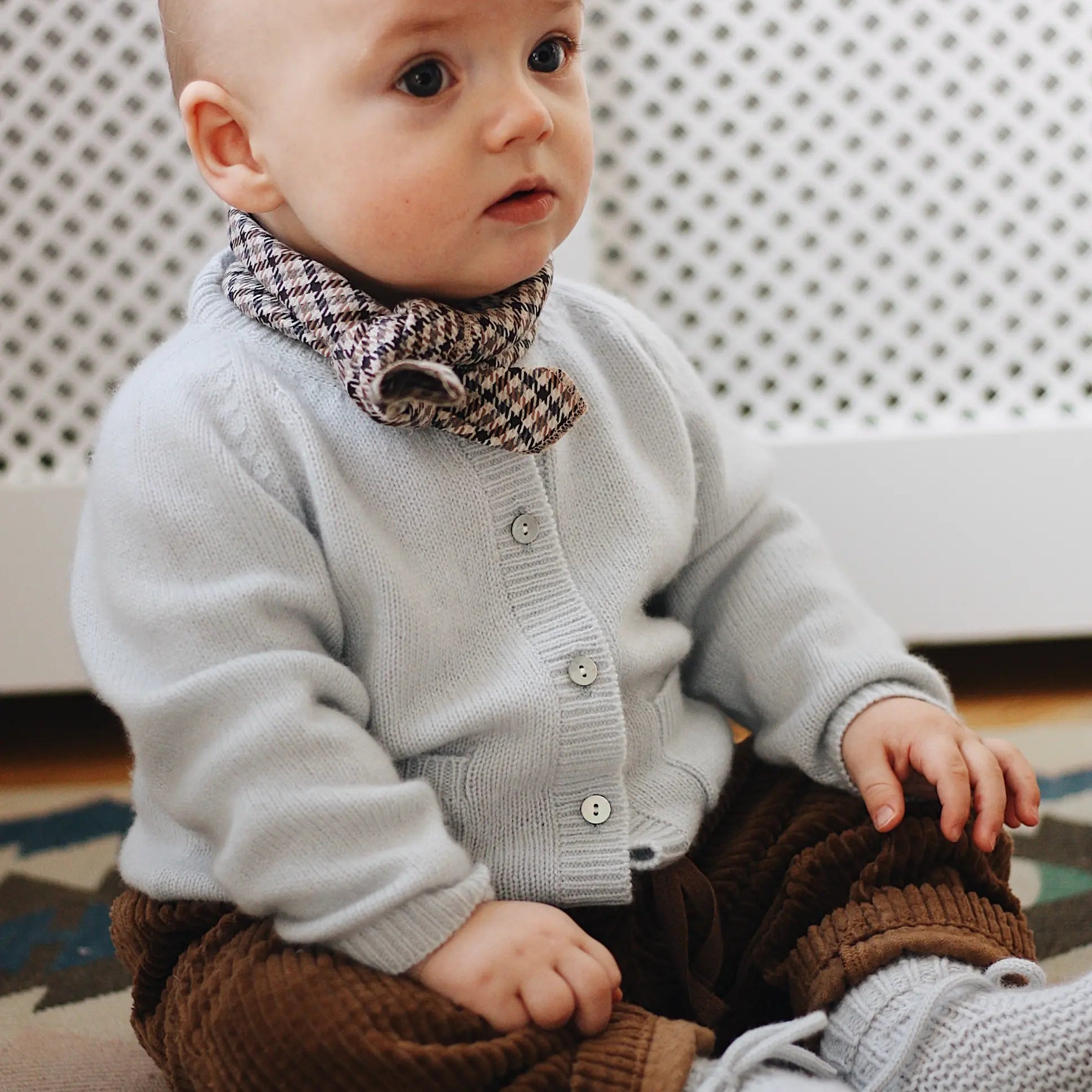 Baby boy wearing Lalaby Bobbie baby cardigan in bluey light blue cashmere