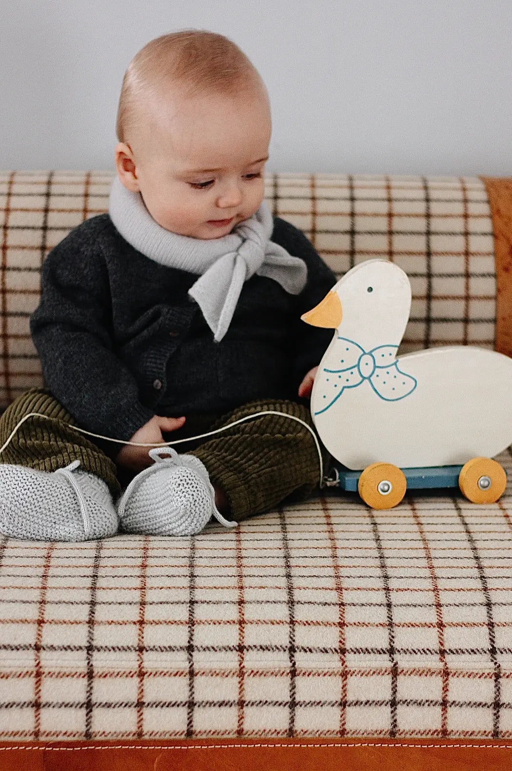 Baby wearing Lalaby Bobbie cardigan in storm grey cashmere