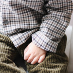 Baby boy wearing Lalaby Charlie baby trousers in forest green cotton mega corduroy