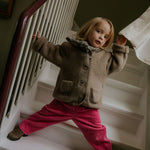Girl wearing Lalaby Charlie trousers for kids in flamingo pink organic cotton mega cord