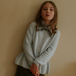 Girl wearing Lalaby Charlie kids trousers in forest green organic cotton mega cord