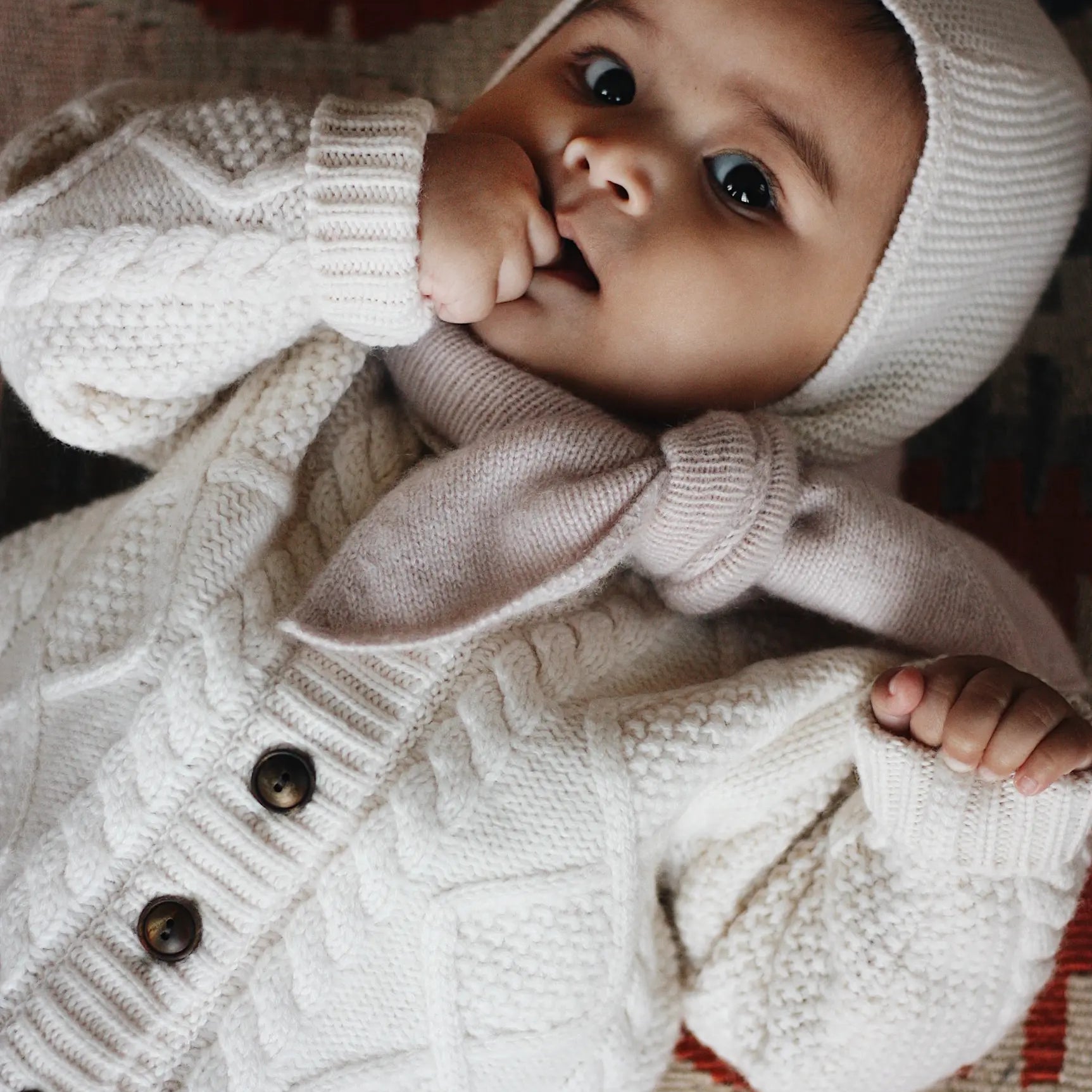 Baby girl wearing Lalaby Coby baby cardigan in natural white merino wool