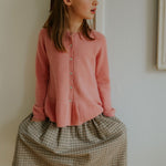 Girl wearing Lalaby Dagmar skirt for kids in tweedy check organic cotton