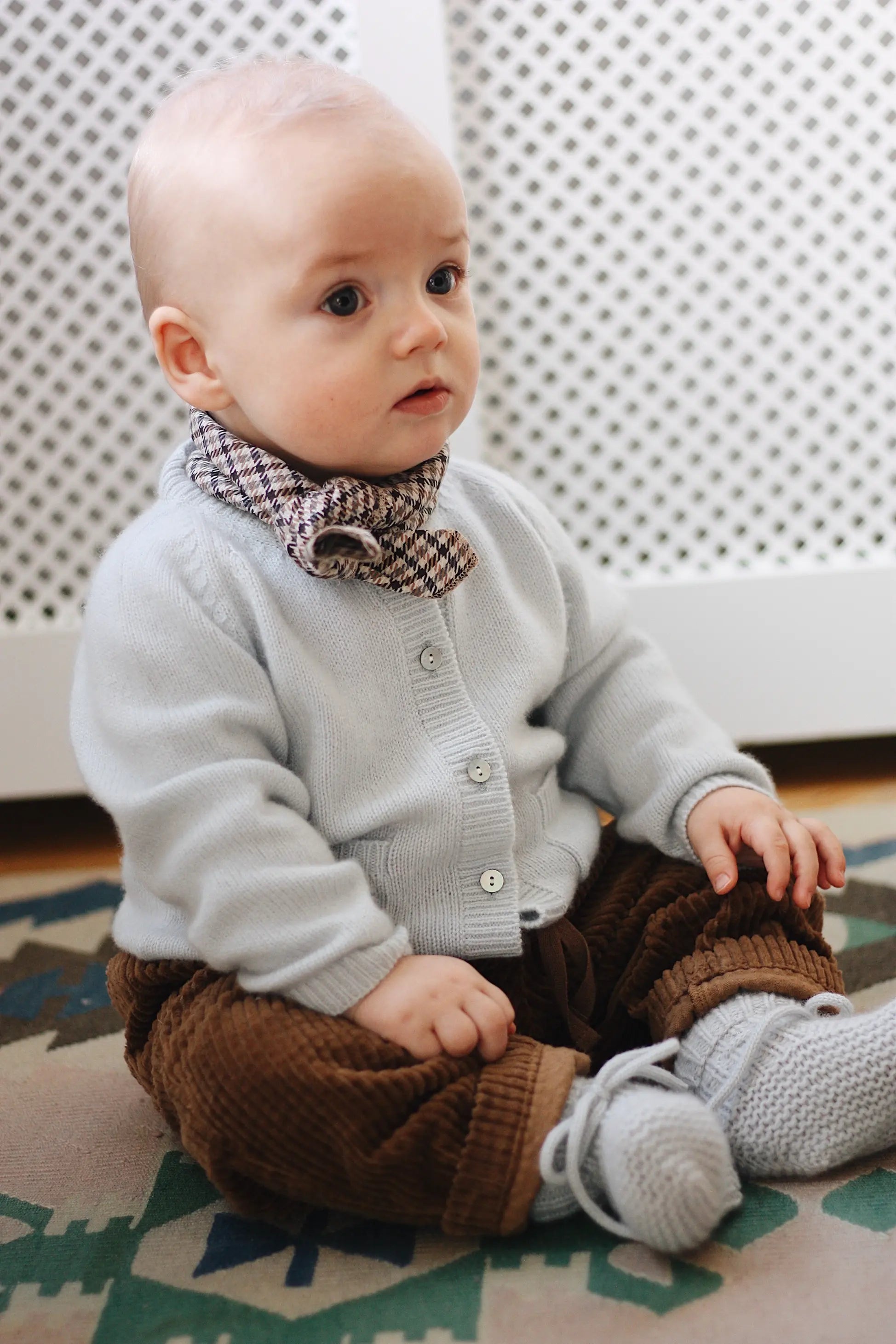 Baby boy wearing Lalaby Eddie scarf for babies and kids in tweedy check organic cotton