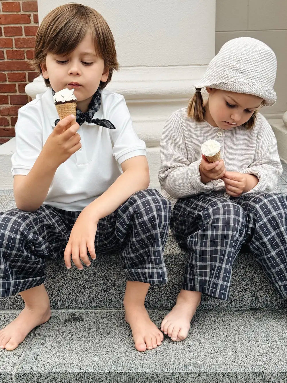 Boy eating ice cream wearing Lalaby Eddie scarf for kids in blue check organic cotton
