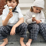 Boy eating ice cream wearing Lalaby Eddie scarf for kids in blue check organic cotton