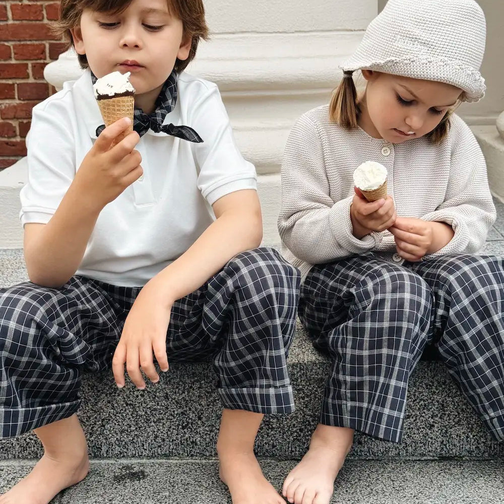 Boy and girl wearing Lalaby Frankie pants for kids in blue check organic cotton, eating ice cream