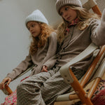 Girl wearing Lalaby Frankie pants for kids in tweedy check organic cotton