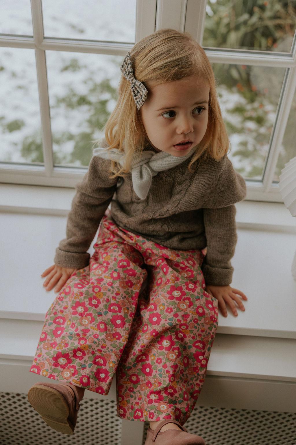 Girl wearing Lalaby Hugo v-neck for kids in a millet brown baby wool, yak and cashnere blend