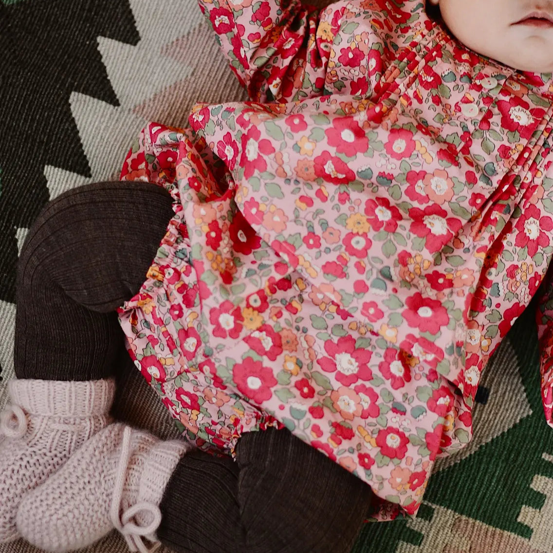 Baby girl wearing Lalaby Mimi baby shirt in berry betsy pink liberty organic cotton