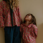 Girl wearing Lalaby Mimi kids shirt in berry betsy pink liberty organic cotton