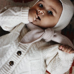 Baby girl wearing Lalaby Mumi balaclava for babies and kids in natural white merino wool