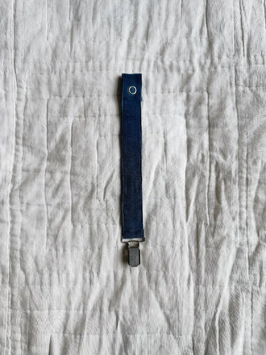 Lalaby pacifier clip in whale blue cotton baby cord with a metal clip for attachment  