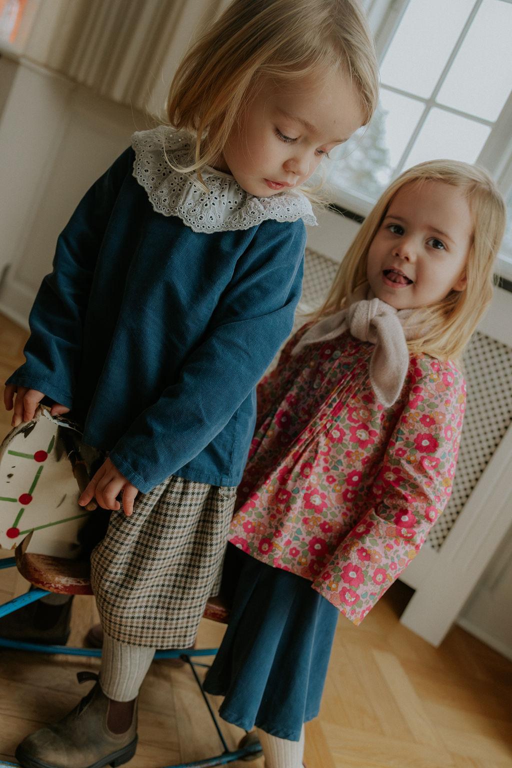 Girl wearing Lalaby Petra skirt for kids in whale blue cotton baby cord