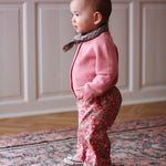 Baby girl wearing Lalaby Pixi baby pants in Berry besty pink liberty organic cotton