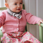 Baby girl wearing Lalaby Pixi baby pants in Berry besty pink liberty organic cotton