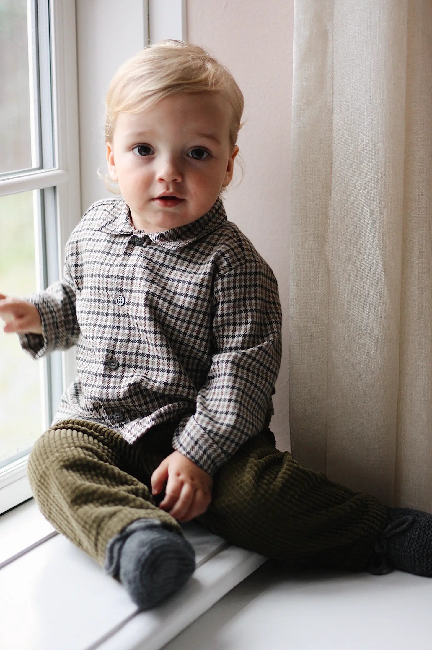 Baby boy wearing Lalaby Saxo baby shirt in tweedy check organic cotton