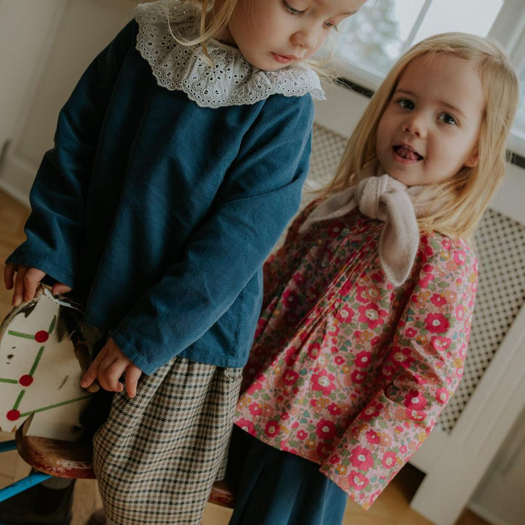 Girl wearing Lalaby Thea kids top in whale blue cotton baby cord
