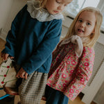 Girl wearing Lalaby Thea kids top in whale blue cotton baby cord
