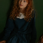 Girl wearing Lalaby Thea kids top in whale blue cotton baby cord