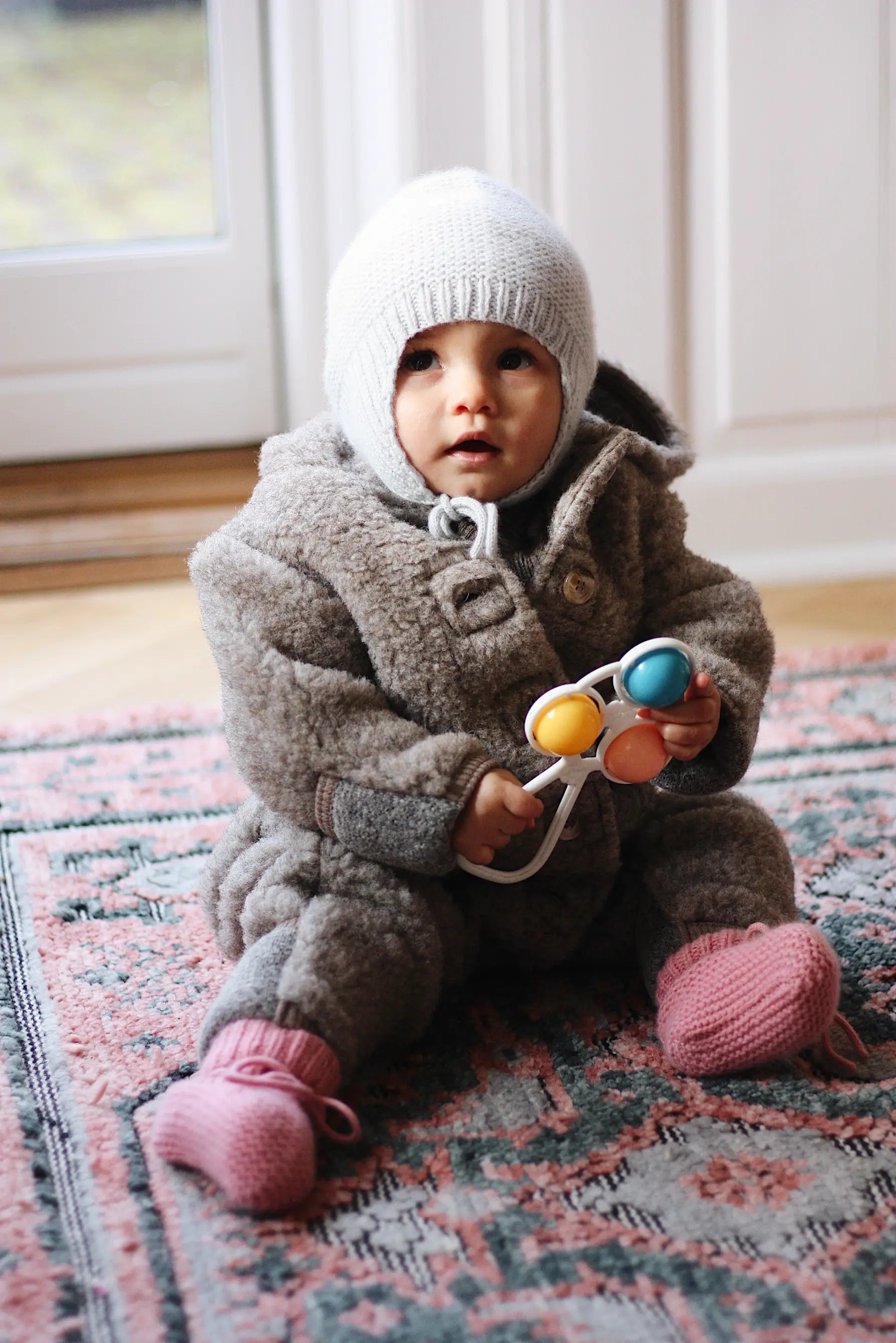 Baby girl wearing Lalaby Thule baby onesie in grizzly brown merino wool