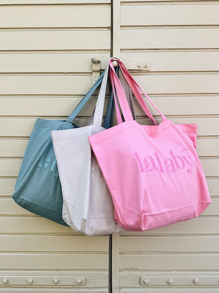 Lalaby Toto tote bags in three colorways; sorbet pink, natural beige and pool blue, made from organic cotton